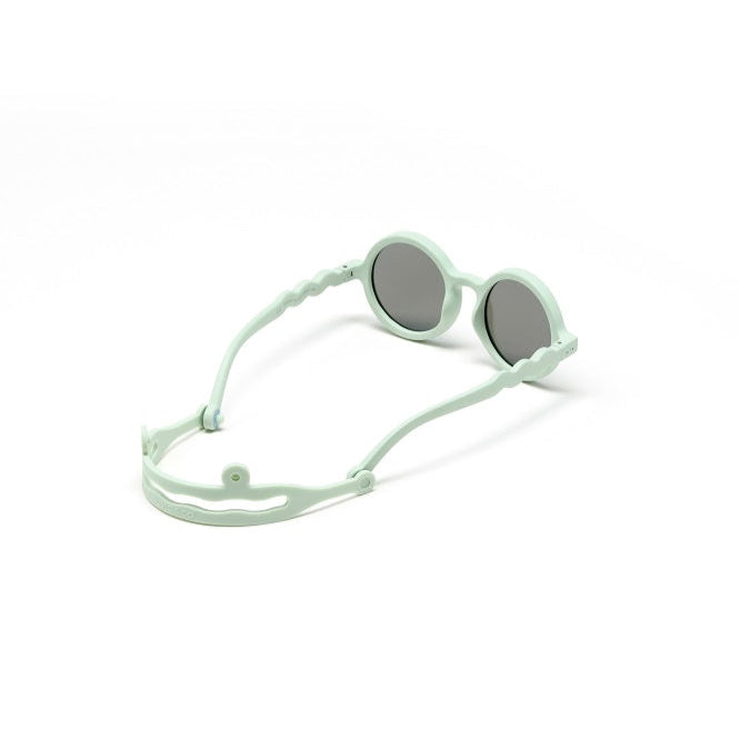 Olivio & Co Round Sunglasses Kids natural light green with adjustable neck strap secured around the wearer's neck.
