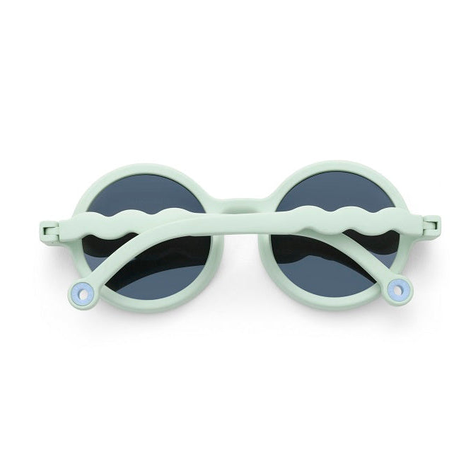 OLIVIO & CO Round Sunglasses Kids/Junior Natural Light Green with dark lenses, arms resting across the lenses.