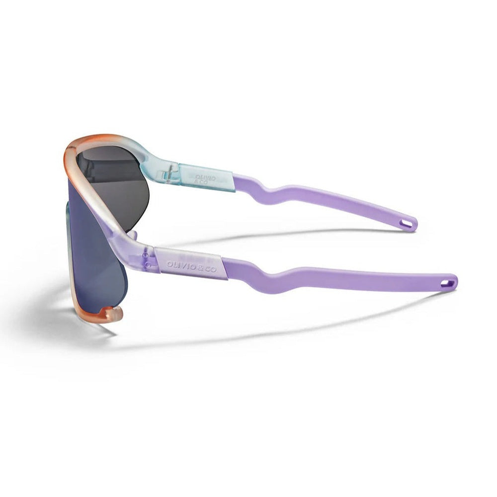 Olivio & Co Sport Sunglasses Kids/Junior Ocean Fantasy with lavender temples and blue mirrored lenses worn by a kid at play.