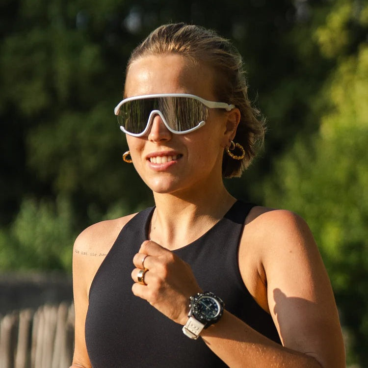 Olivio & Co Sport Sunglasses white-framed with reflective lenses worn by a woman outdoors