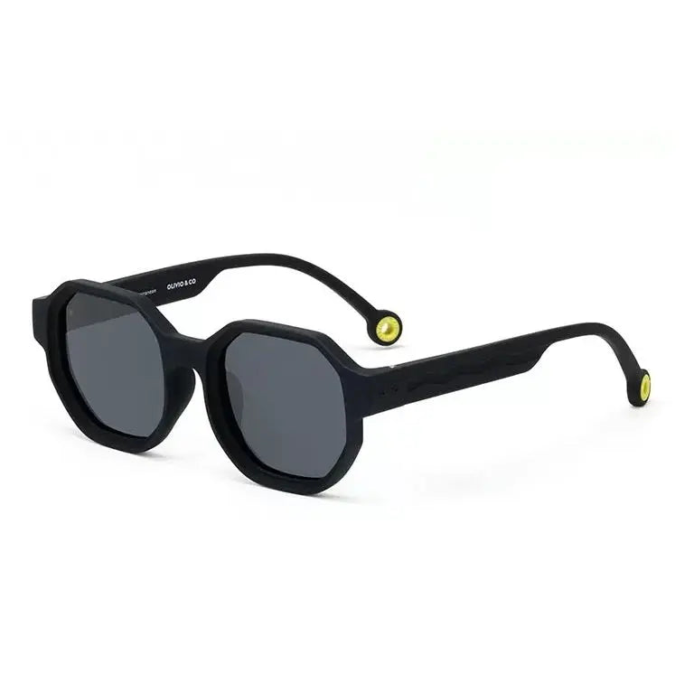 Olivio & Co Square Sunglasses Creative Edition D Squid Black on white surface; black square frames, dark lenses, yellow temple tips.