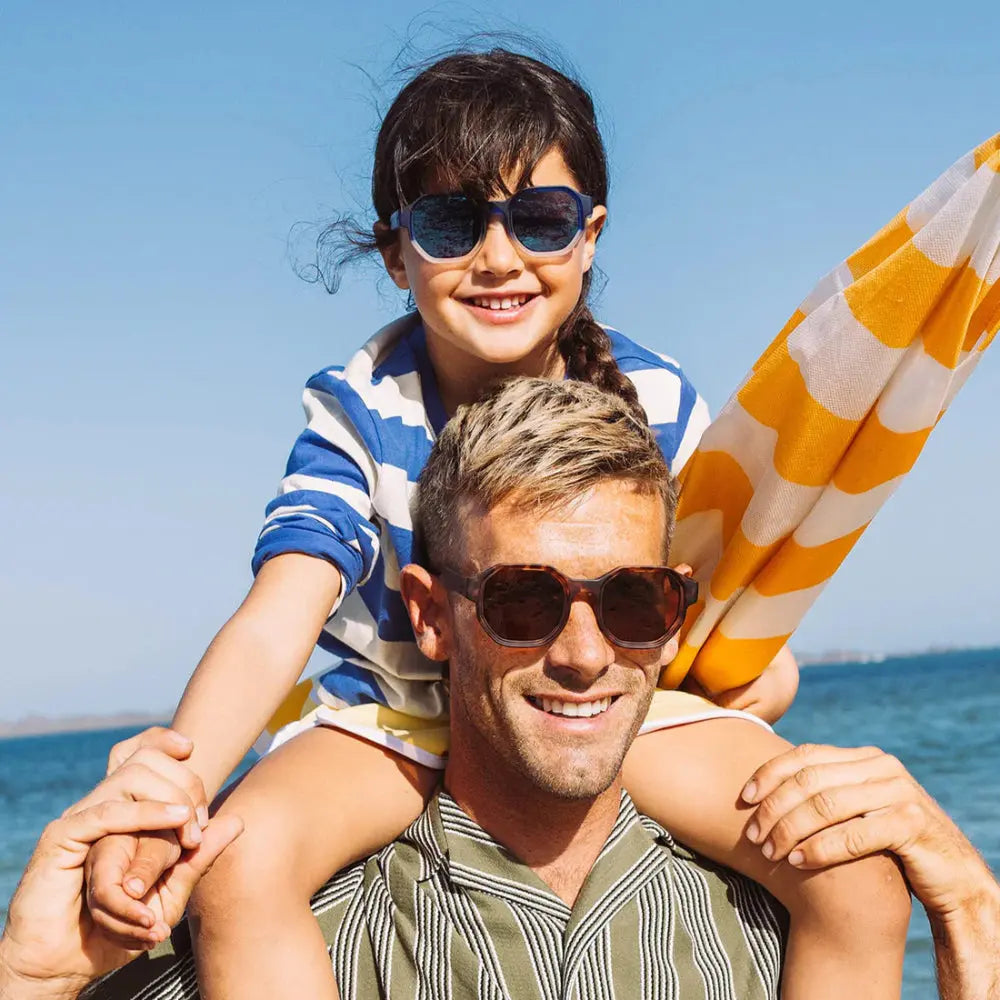 Olivio & Co Square Sunglasses Adult Creative Edition D tortoiseshell worn by a smiling man at the beach.