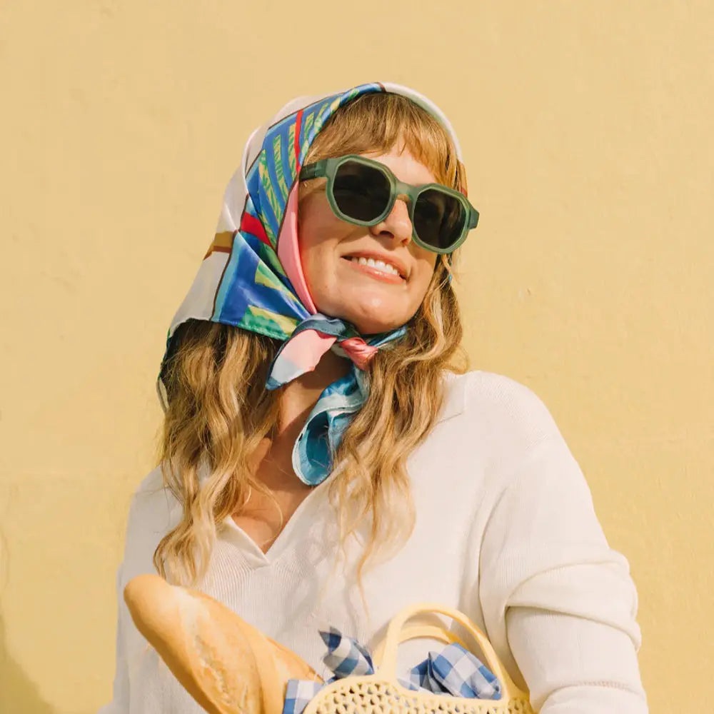 OLIVIO & CO Square Sunglasses Creative Edition Olive Green, worn by a smiling woman with a colorful headscarf.