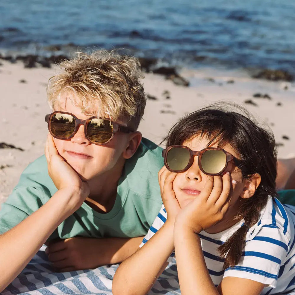 Olivio & Co Square Sunglasses Kids/Junior Creative Edition D Tortoiseshell worn by two kids at the sunny beach.
