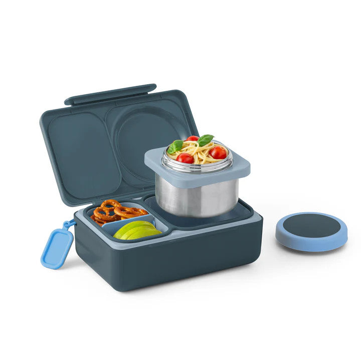Omiebox Up lunch set in navy blue with blue lid; open two-tier box holds pasta in stainless pot and fruit/pretzels.