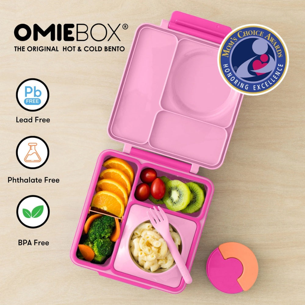 OmieBox Version 2 pink lunch box with divided compartments; pink utensil stored, open to reveal orange slices, kiwi, pasta.