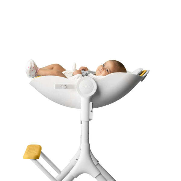 Oribel Cocoon Z High Chair Lounger in white with yellow foot pedals and baby seated