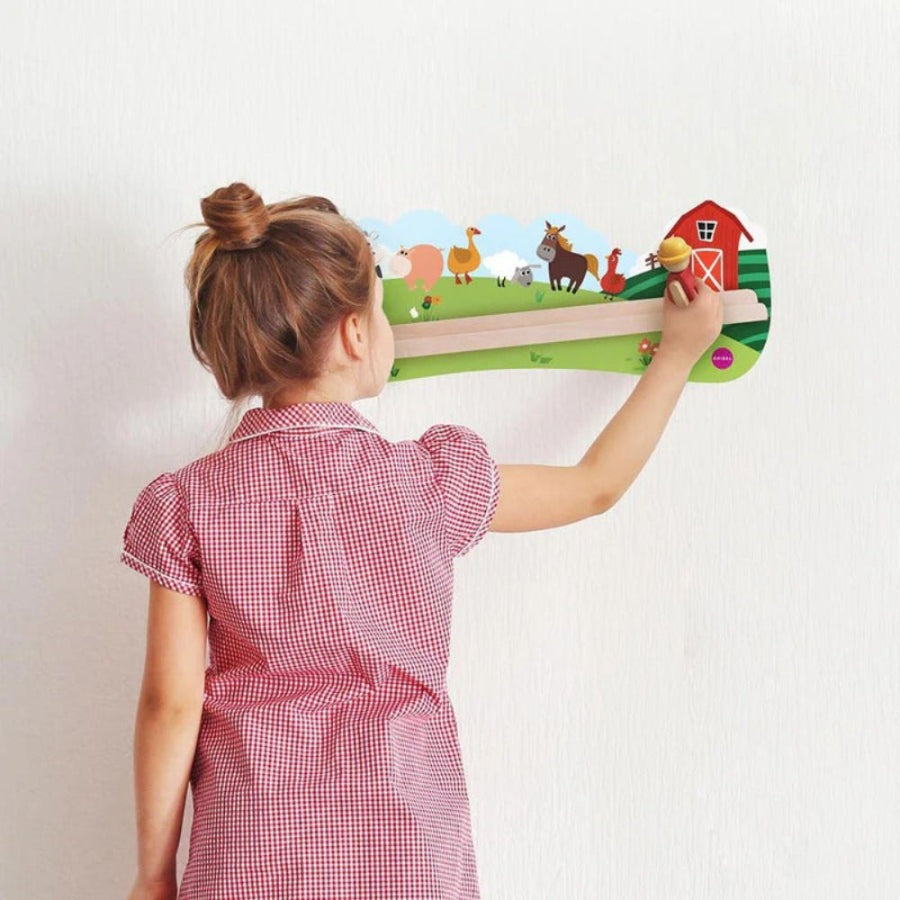 Oribel VertiPlay Wall Toys Old MacDonald mounted on wall; a child in a red gingham dress interacts with a farm scene.
