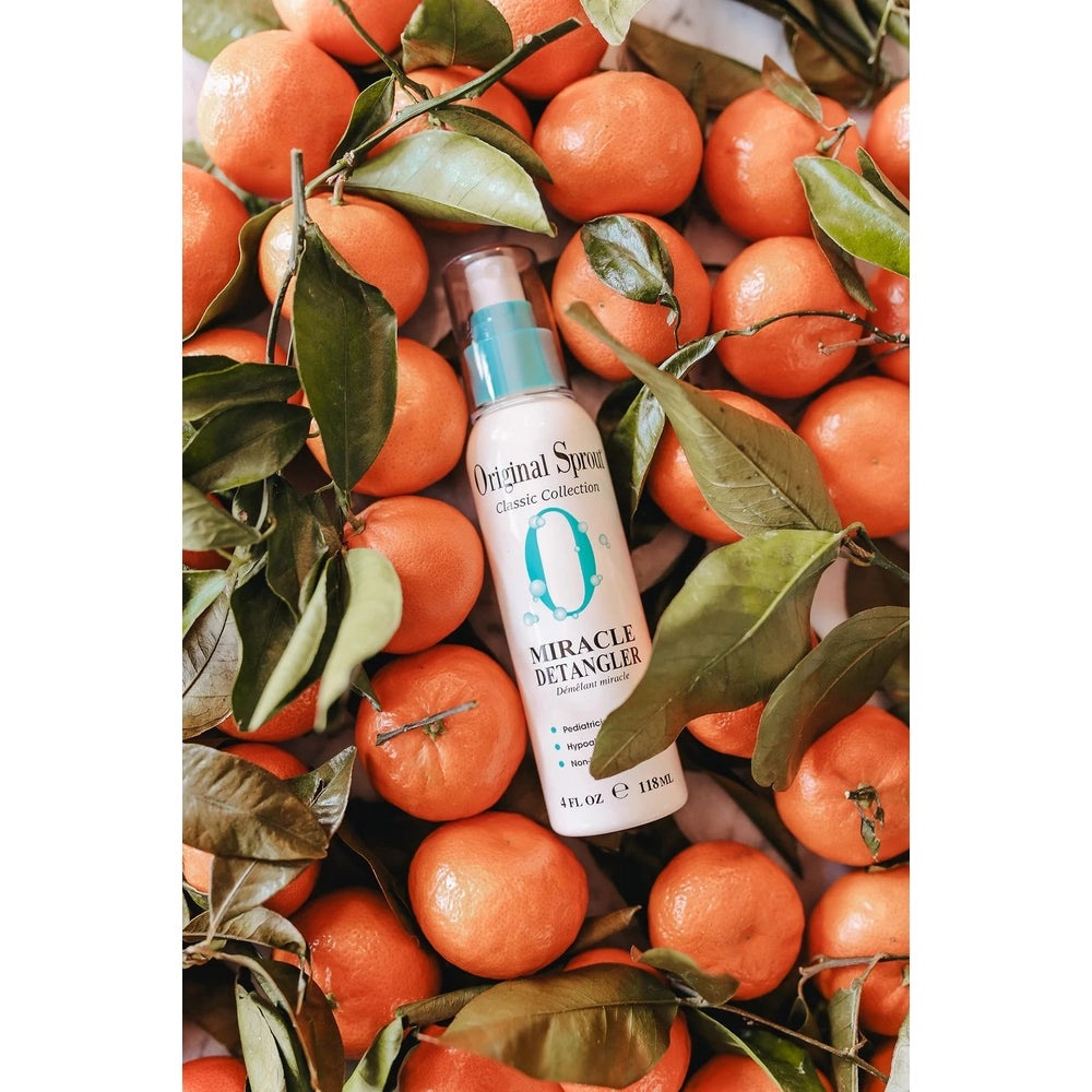 Original Sprout Miracle Detangler Spray 12 oz bottle with turquoise pump among fresh oranges