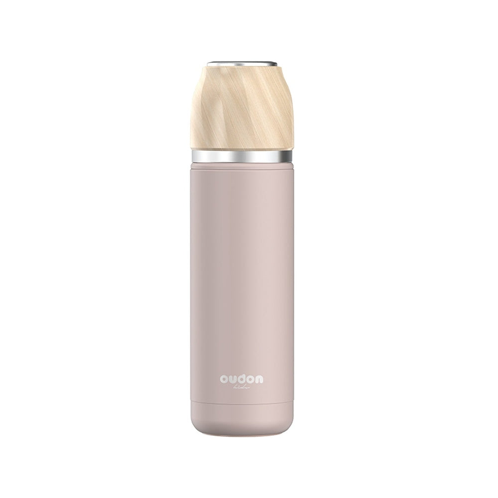 Oudon thermal drink bottle in pink stainless steel with a light wood cap and silver ring.