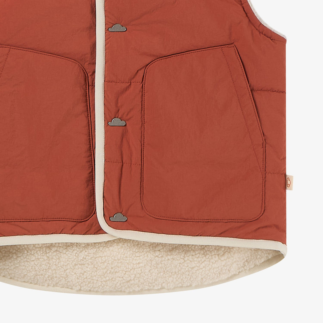 Nest Designs Redwood Burl Cozy Crumbs Reversible Fleece Vest detail with snap placket, outlined pocket and cream curved fleece hem