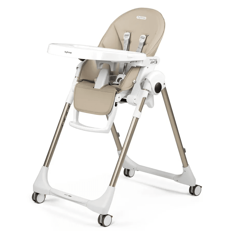 Peg Perego Prima Pappa Zero 3 high chair in beige with white frame, adjustable tray, and caster wheels.