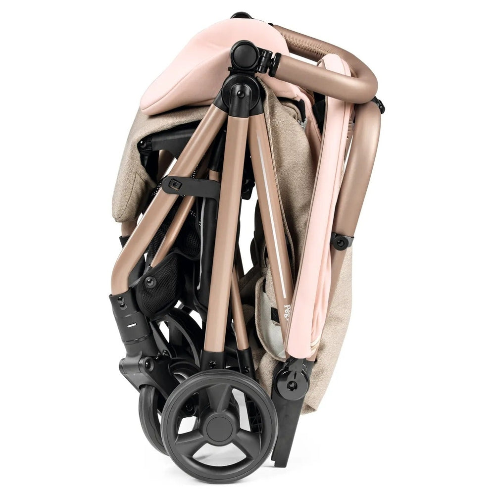 Peg Perego Selfie Plus Stroller folded compactly, rose-gold frame with pink fabric for easy travel.