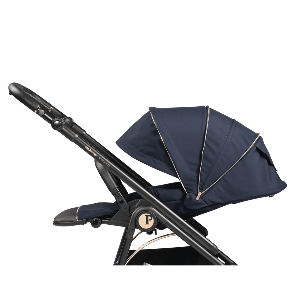 Peg Perego Veloce stroller in navy with gold-trimmed canopy, shown with adjustable handle and foot muff.