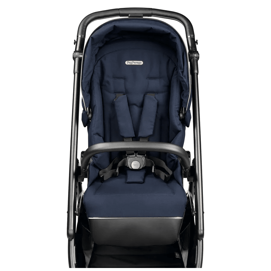 Peg Perego Veloce Stroller in navy with foot muff, padded harness secured for baby.