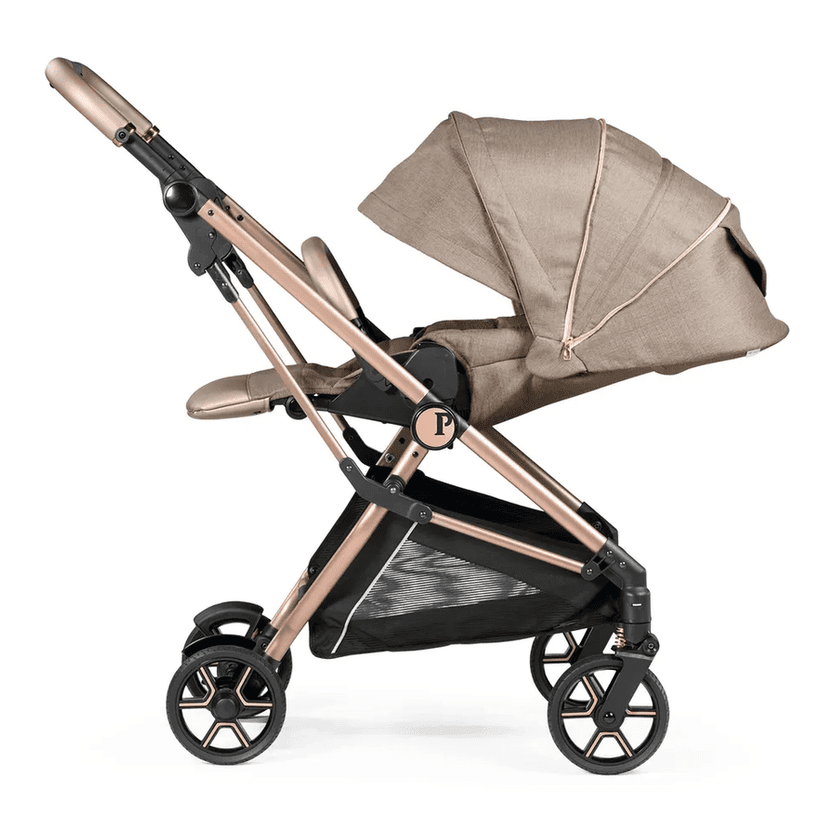 Peg Perego Vivace Stroller in rose-gold frame with beige canopy, showing sturdy frame, large wheels, and under-seat storage basket.