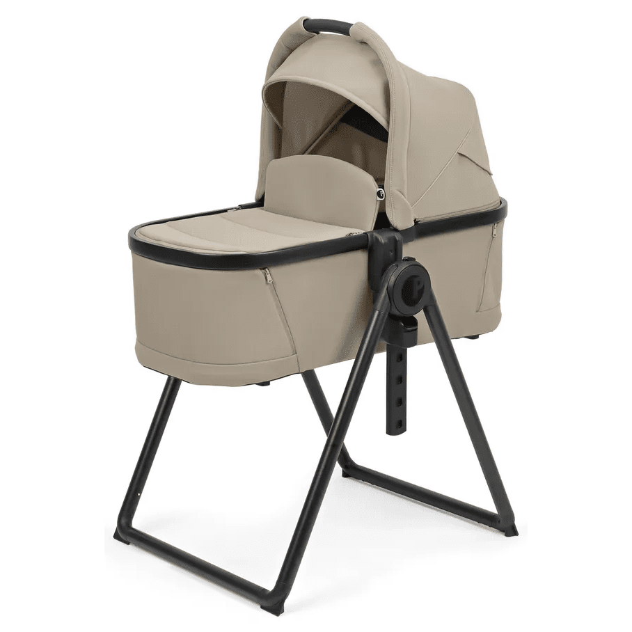 Peg Perego YPSI Bassinet with Stand By Me in beige, mounted on a sturdy black metal frame with canopy.