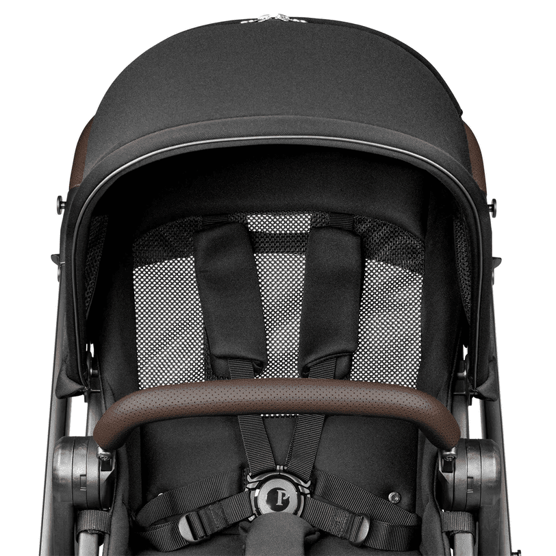 Peg Perego YPSI Stroller in charcoal gray with brown faux-leather handle, showing its 5-point harness.