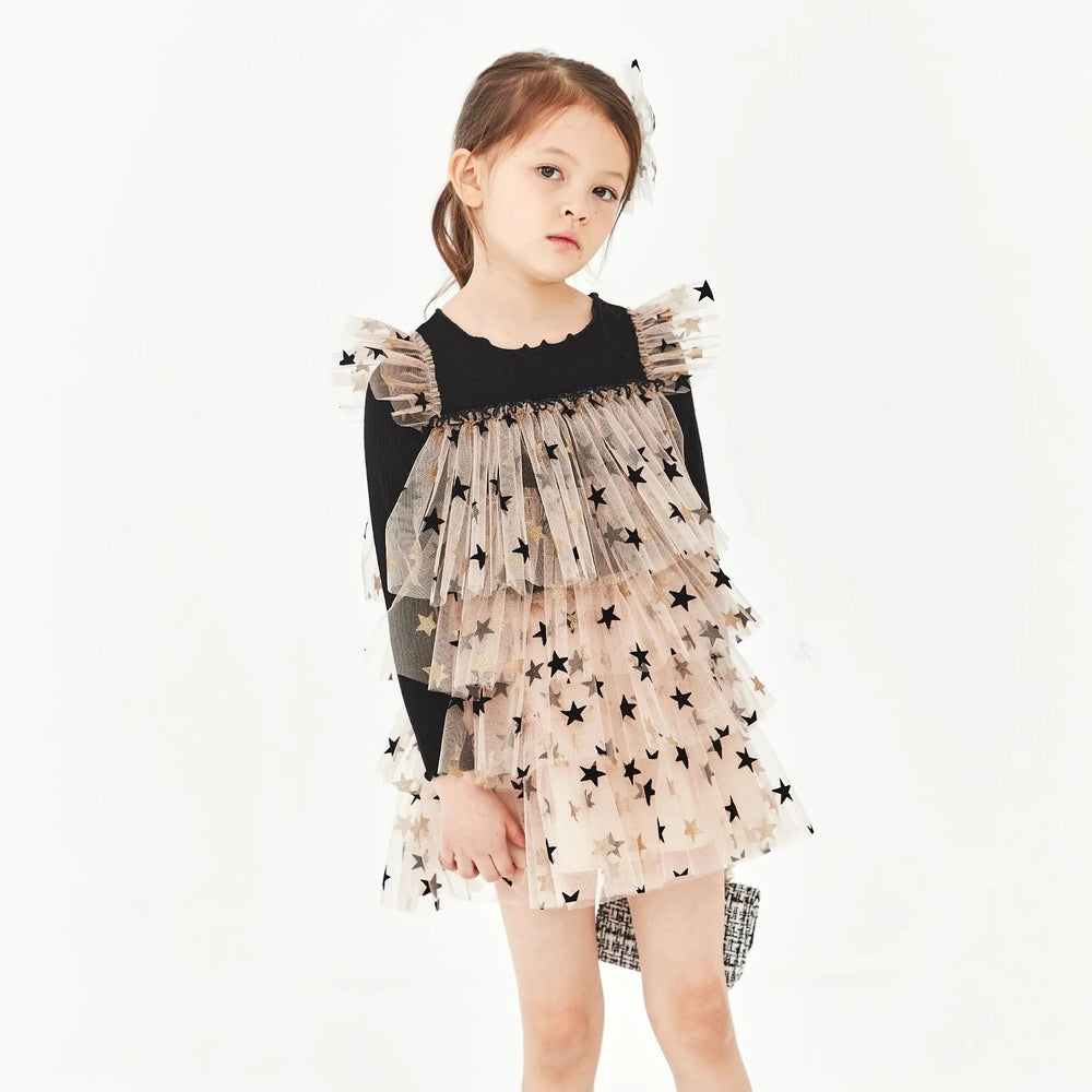 Petite Hailey Layered LS Tutu Black Star dress worn by a girl, beige starry tulle layered over a black sweater.
