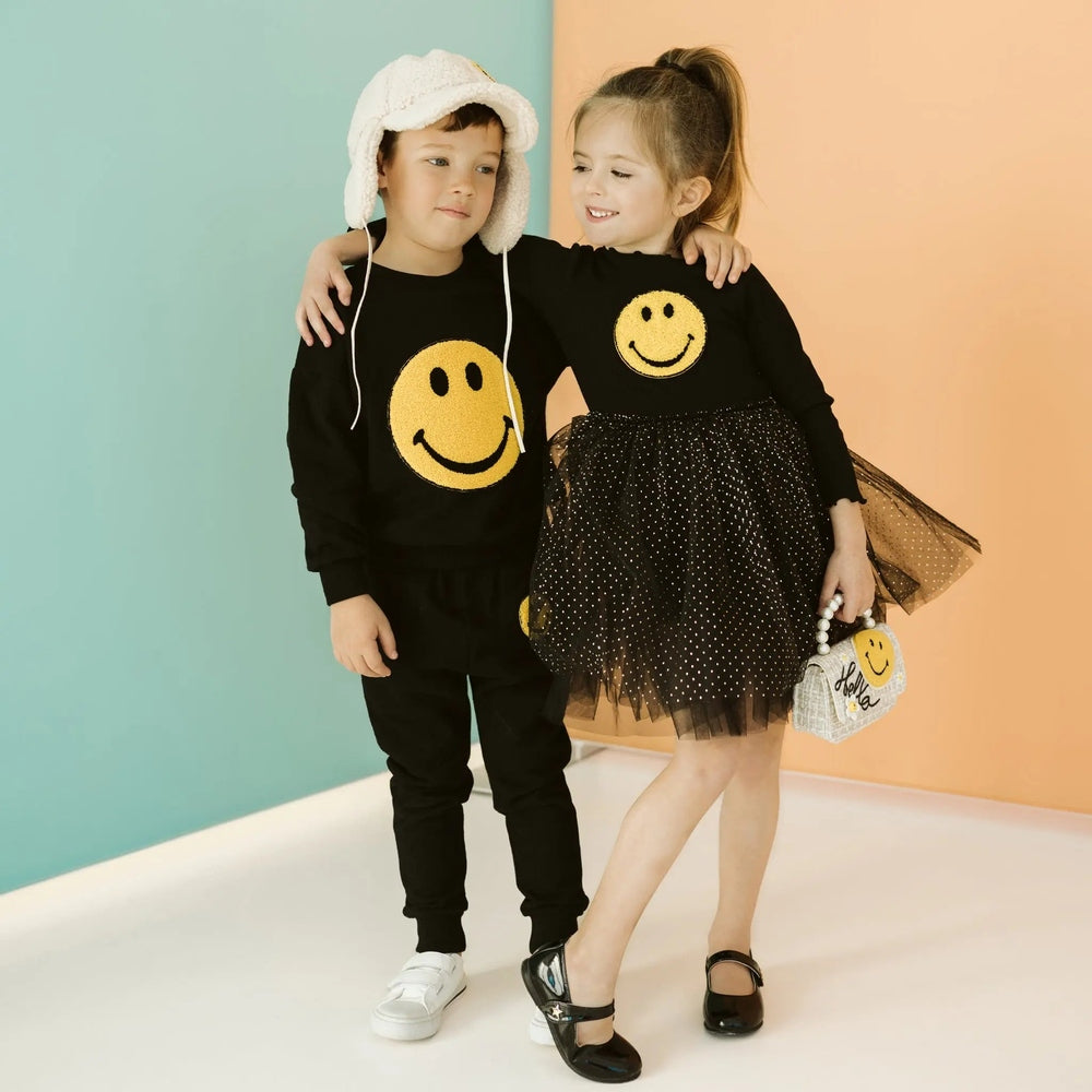 Petite Hailey Smile Tutu Black: girl twirling in black top with gold smiley and sparkly dotted tulle skirt