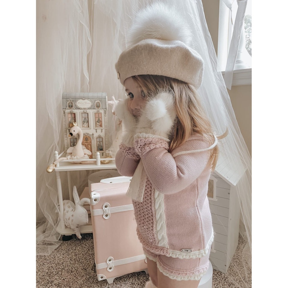Petite Maison Kids cream wool beret with white pom-pom on a girl in pink knitwear.
