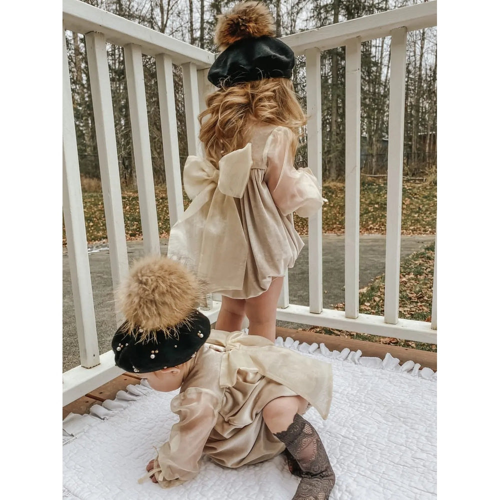 Petite Maison Kids Helena Velour Romper in beige; standing baby shows oversized back bow while crawling baby wears matching romper.