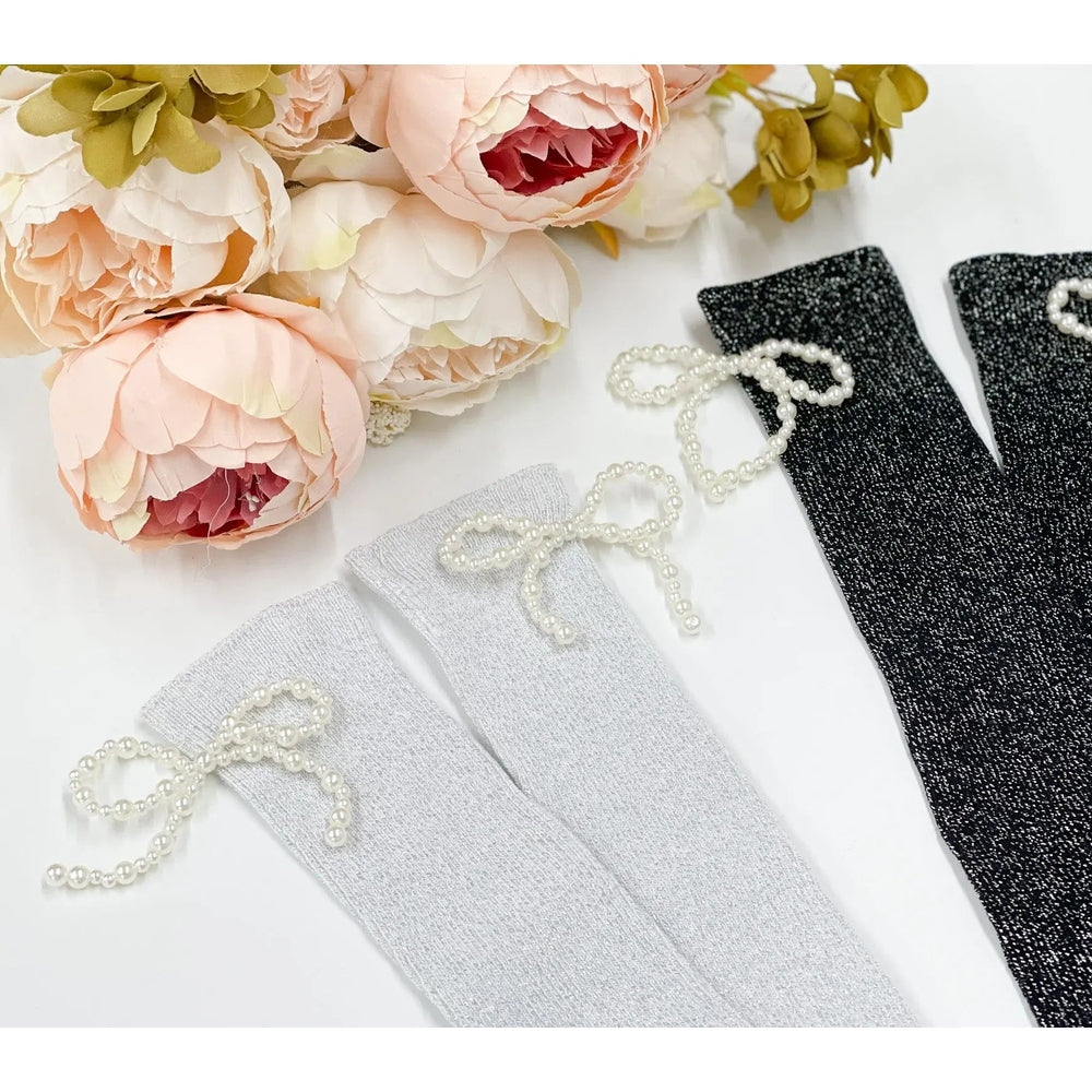 Petite Maison Kids Perla Shimmer Socks in silver, white and black glitter, each with pearl bow, neatly arranged.