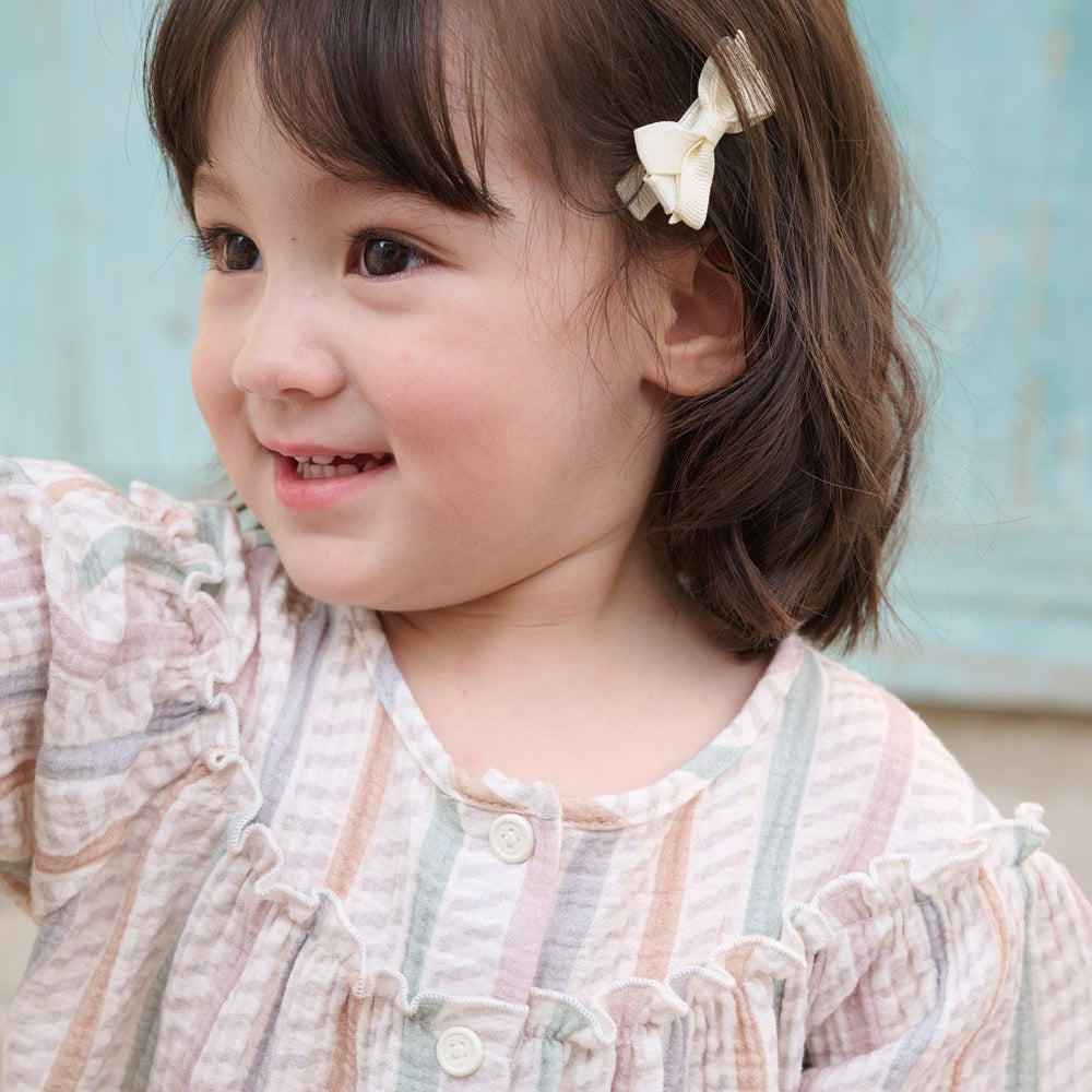 Child wearing a patterned dress with a light blue background