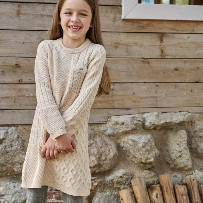 PETITE REVERY cotton knit dress in cream worn by smiling girl; long sleeves with cable knit pattern.