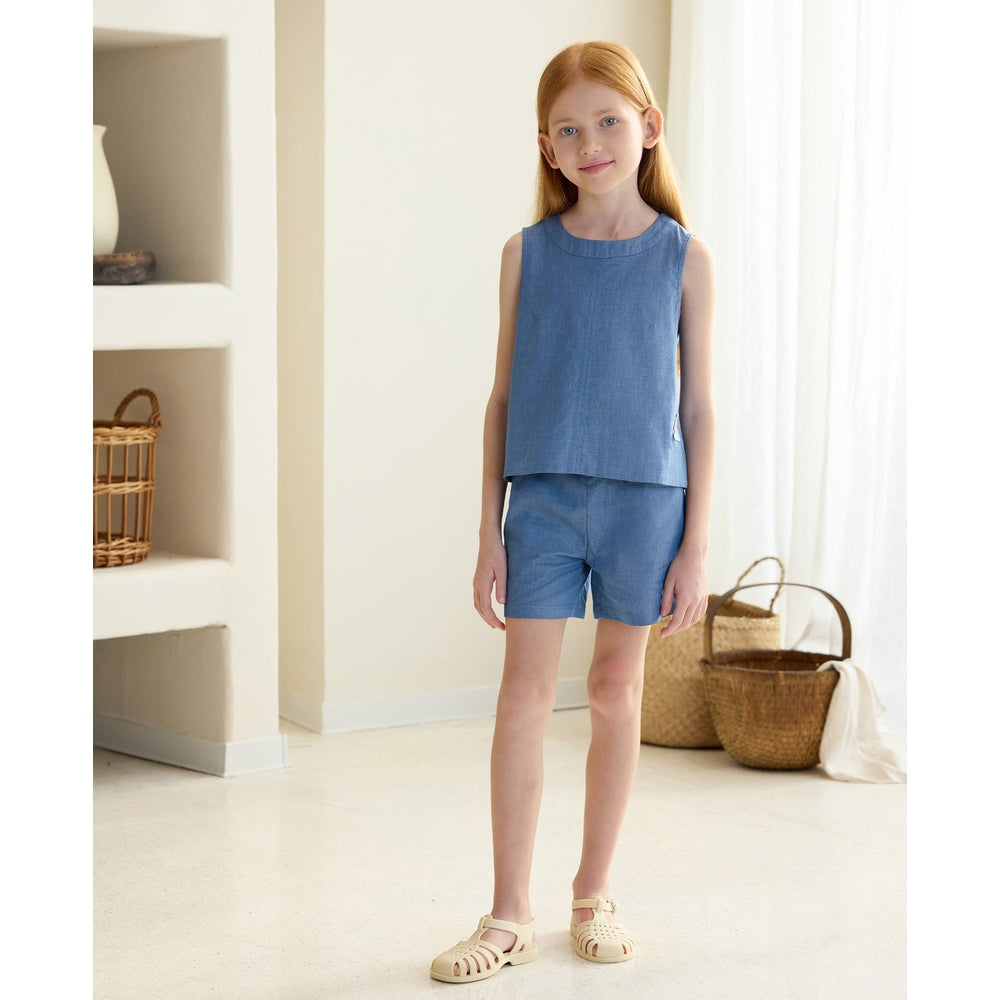 Petite Revery Denim Shorts Sky set worn by a girl in a matching sky blue sleeveless top.