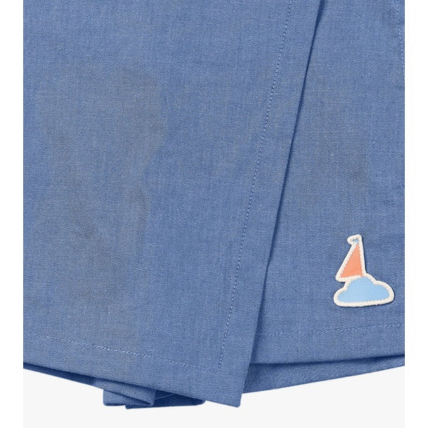 Petite Revery Denim Skort Sky, blue denim with sailboat patch on hem, toddler bottom.