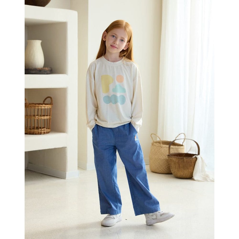 Petite Revery French Terry Drop Shoulder Long Sleeve Sweatshirt Jet Stream on a girl, blue pants, standing with hands in pockets.