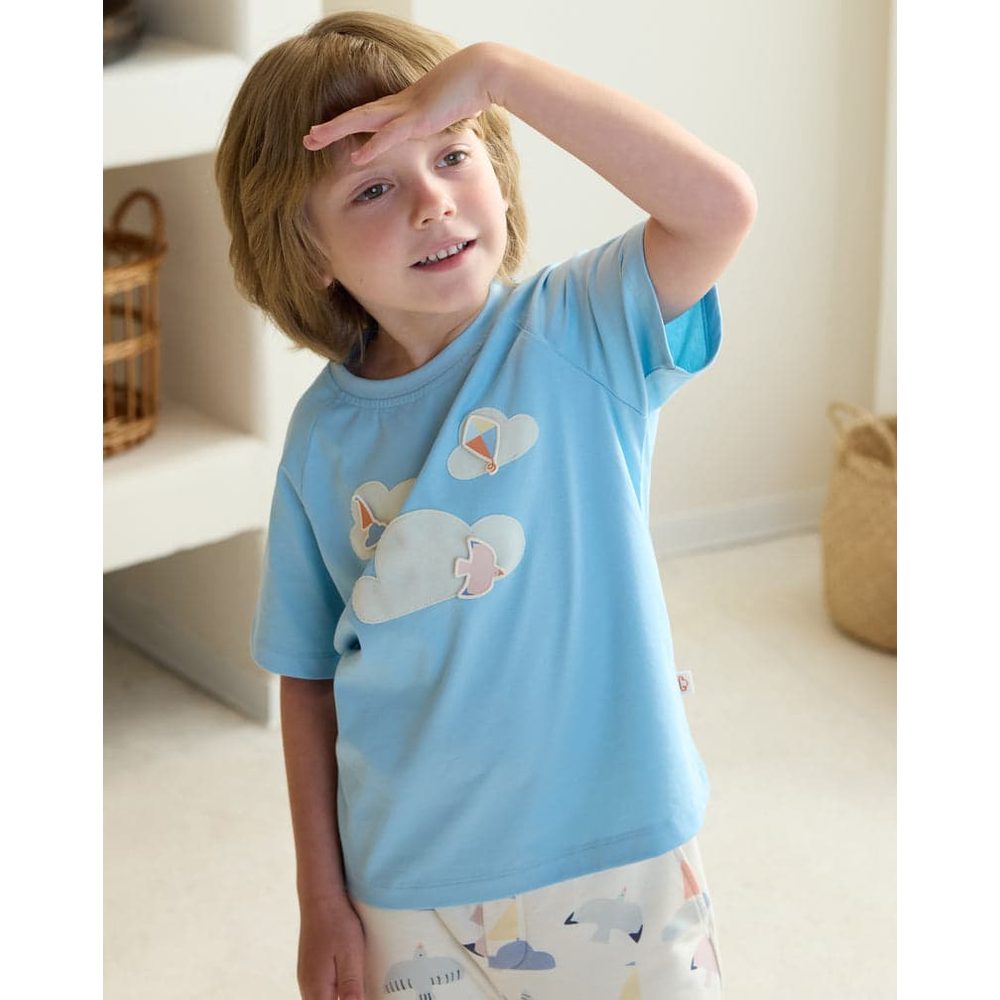 Petite Revery Forget-Me-Not quick-dry cotton raglan tee worn by toddler shielding her eyes.