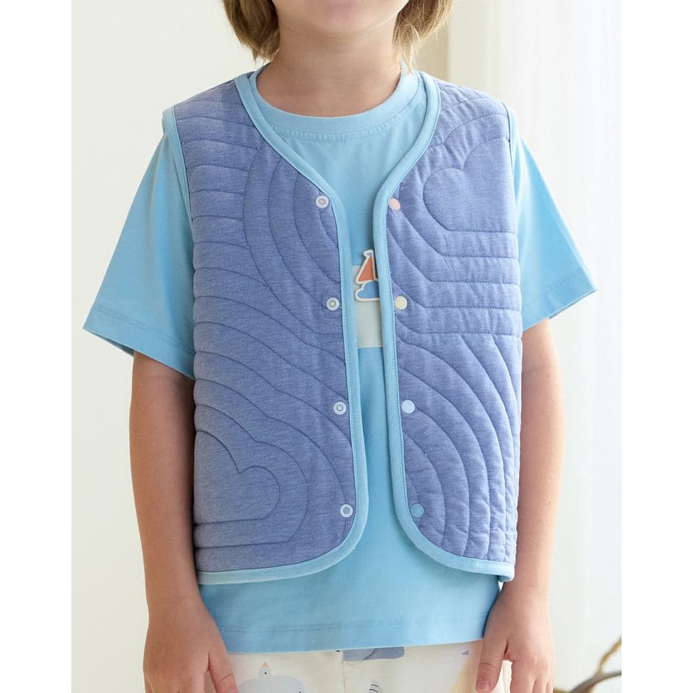 Petite Revery Quilted Cloud Vest Forget-Me-Not worn by a toddler over a light blue tee, showing snap buttons and padded warmth.