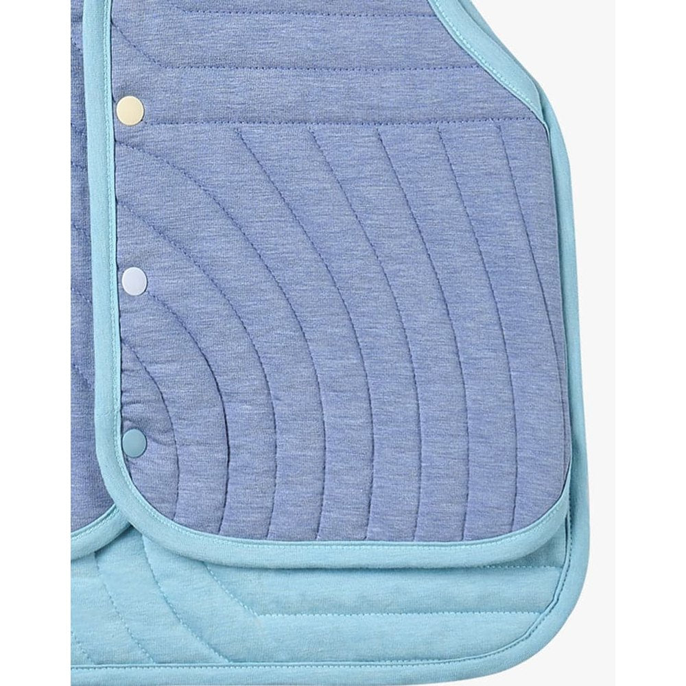 Petite Revery Quilted Cloud Vest Forget-Me-Not in blue with teal trim, showing curved quilted panels and snap closures.