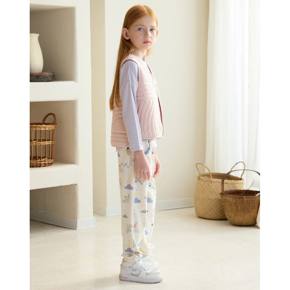 Petite Revery Quilted Cloud Vest Rose Smoke worn by a girl standing indoors, showing its quilted panels and soft color.