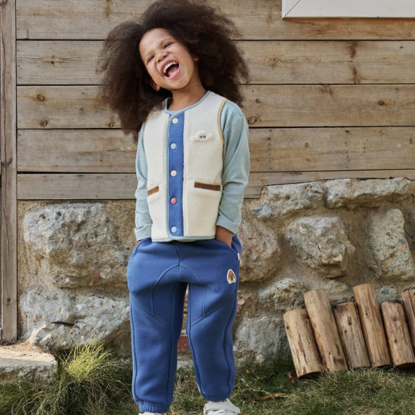 Petite Revery recycled fleece kids pants in deep sea blue worn by child outdoors