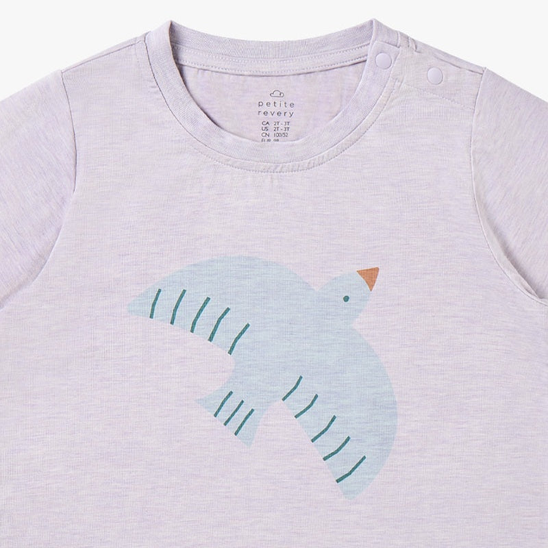 Petite Revery Short Sleeve Tee Lavender Blue where a pale blue bird graphic is printed on soft lavender fabric.