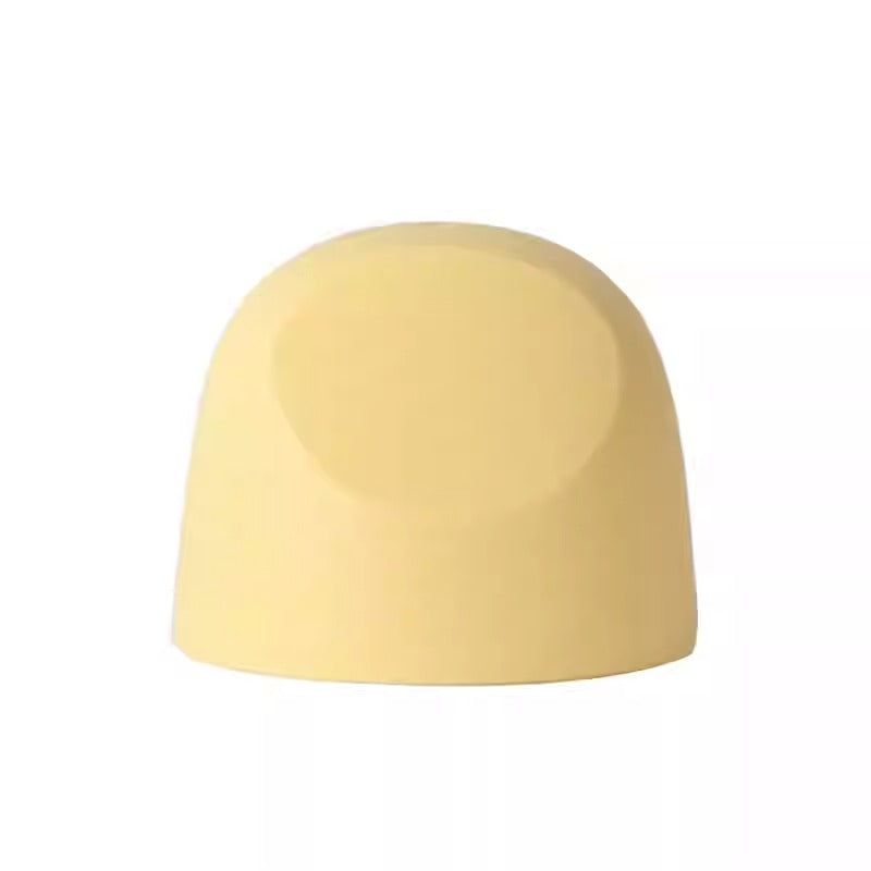 Pigeon Baby Bottle Hood in pale yellow silicone resting as a protective nipple cap.