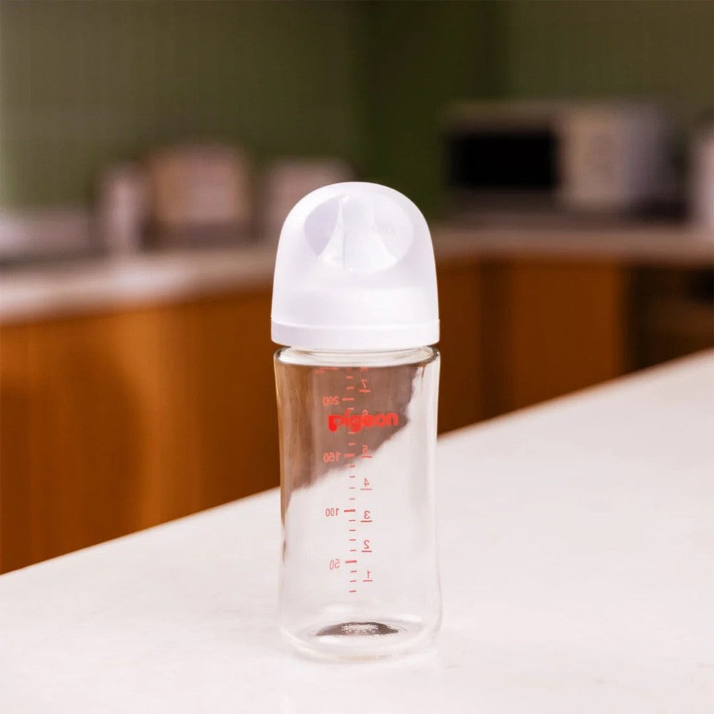 Pigeon Glass Bottle 8oz with M Nipple standing upright on a kitchen counter, with red measurement markings visible.