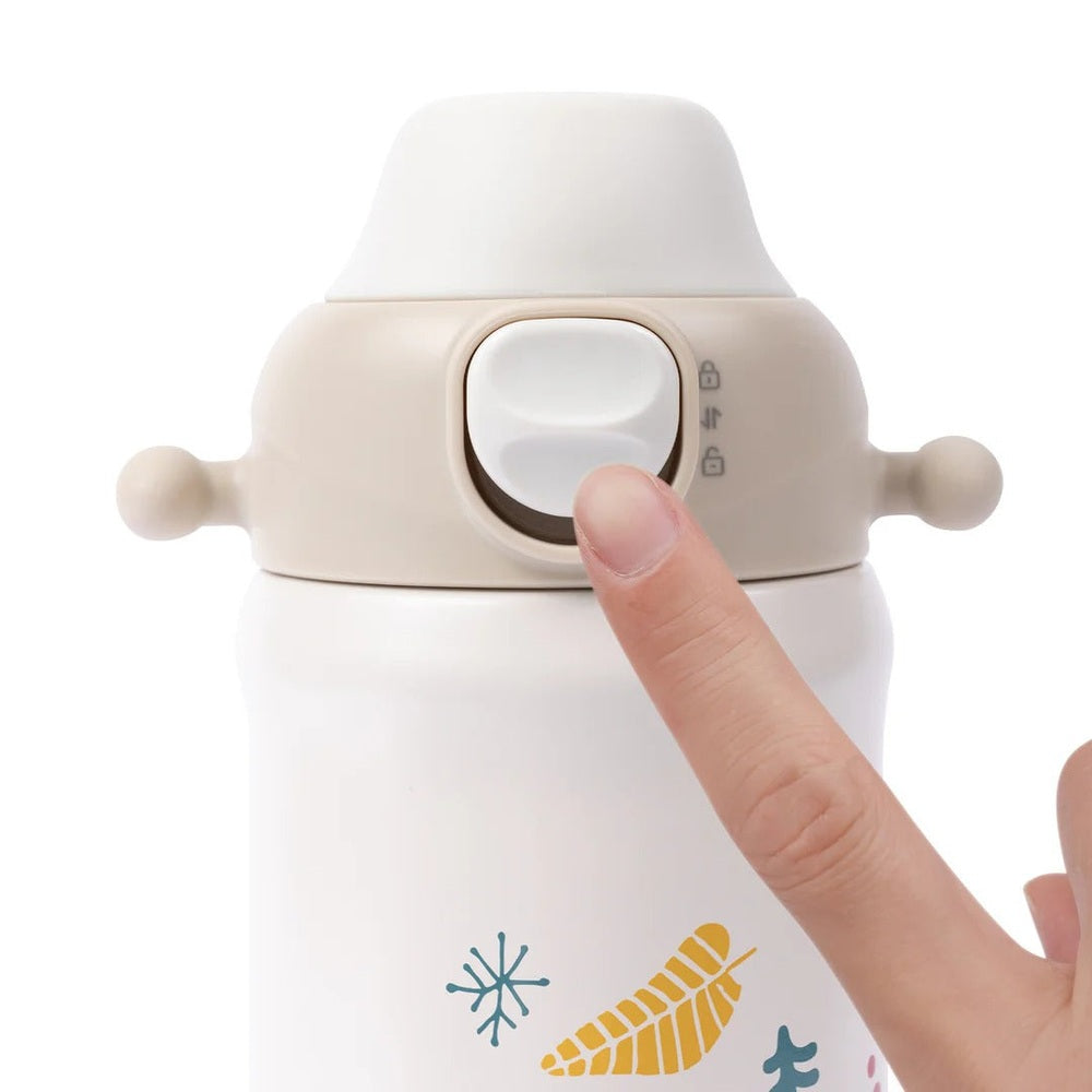 Pigeon Kids Stainless Steel Thermos Drinking Cup; white bottle with beige lid, user pressing the switch to open the spout.