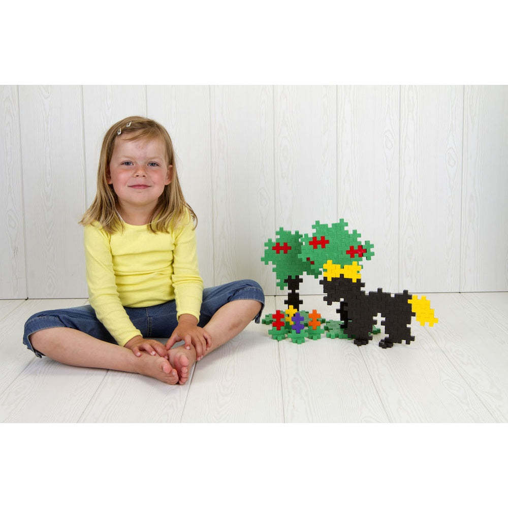 Plus-Plus Big 400 Educational building toy: a girl sits beside a black horse with yellow mane and green trees.