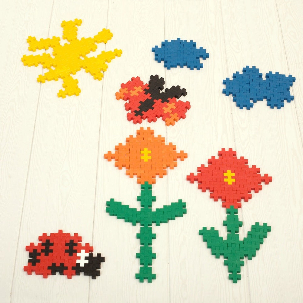 PLUS-PLUS Mini 3600 Educational construction toy set displaying pixel flowers, blue clouds, a red ladybug, and green stems.