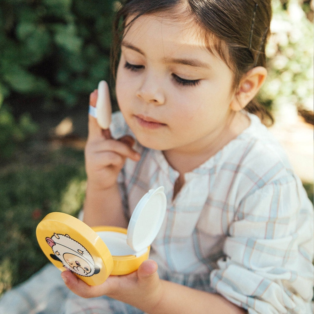 Puttisu Safe Baby Mild Sun Cushion SPF50+ Pa++++ compact, yellow panda design, shown as a child applies sunscreen.