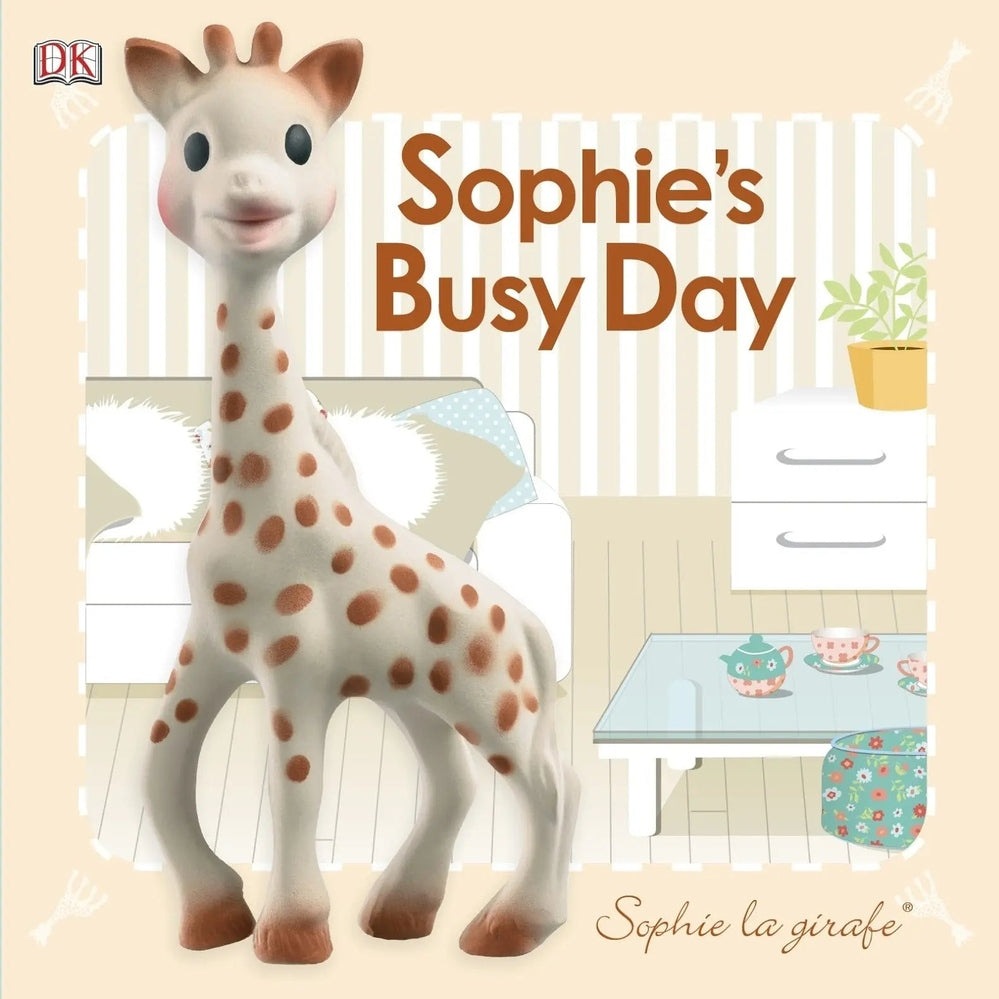 Qhouse Kids Sophie La Girafe Book set in a pastel nursery with a smiling giraffe toy near a white dresser.