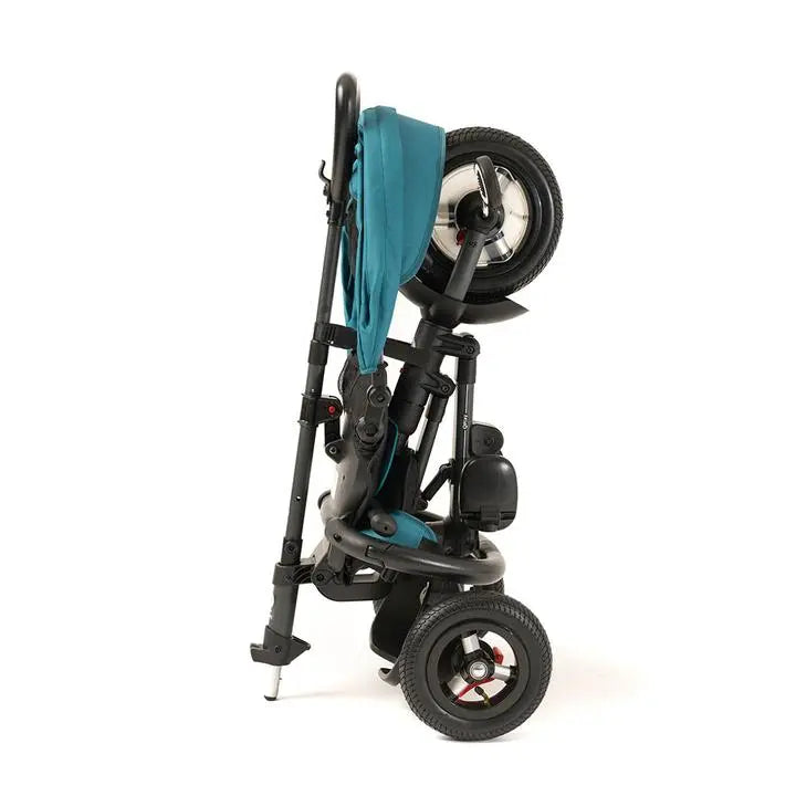 Qplay Rito Plus Ultimate Folding Trike folded for compact storage, turquoise fabric seat and wheels visible.