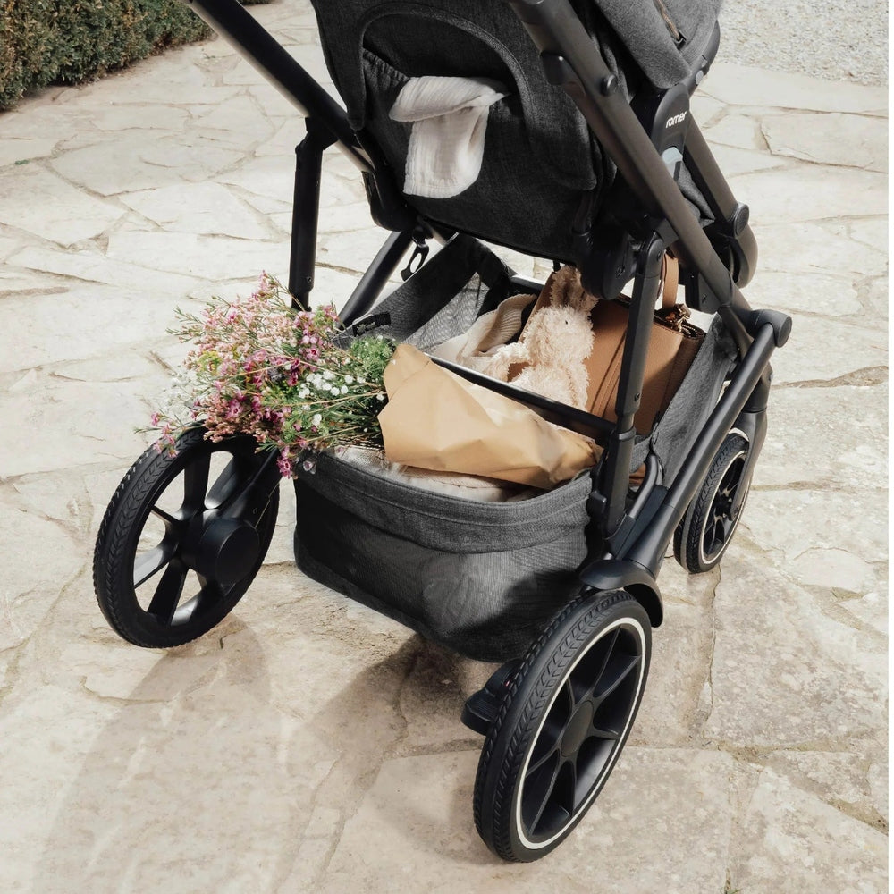 Romer Tura Stroller in dark gray with roomy undercarriage basket holding flowers and a bag.