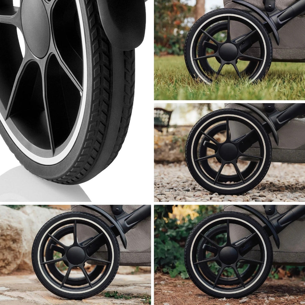 Romer Tura Stroller in black with large alloy wheels rolling smoothly across grass and gravel.