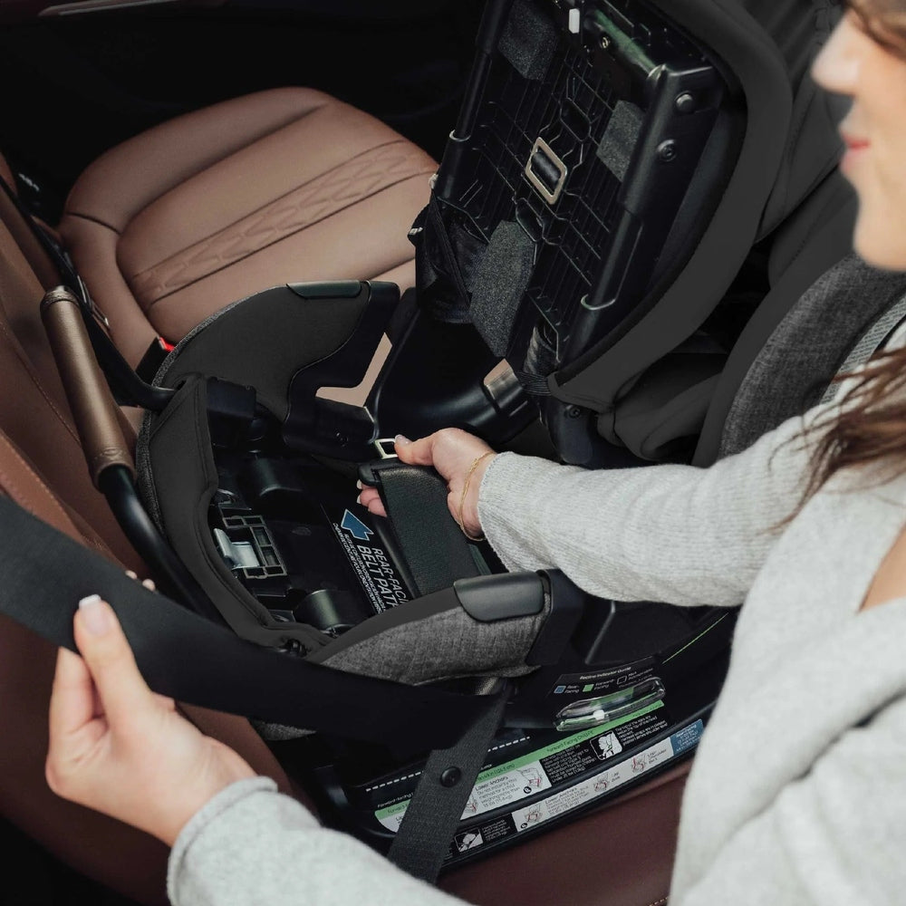 ROMER Romer Veni Convertible Car Seat being installed in a car as straps are tightened.