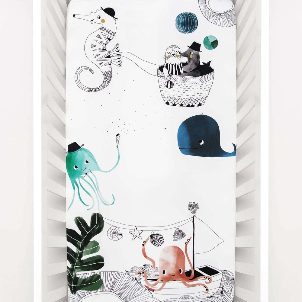Rookie Humans cotton crib sheet with underwater scene in teal and pink, featuring whale, octopus, seahorse.